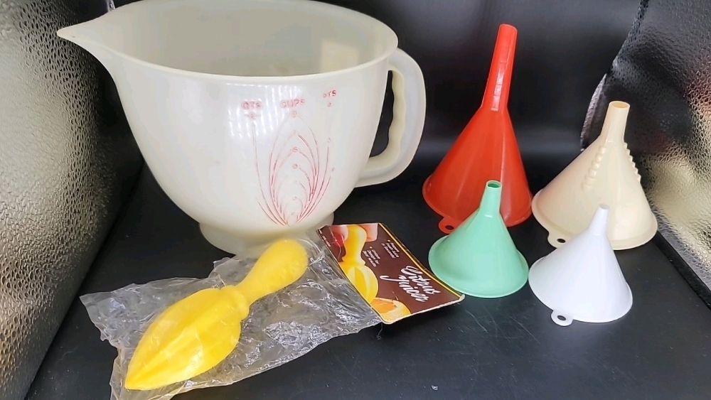 Vintage Tupperware mix n stor and pour measuring bowl w handle and 4 varying size funnels, plus new in package citrus juicer