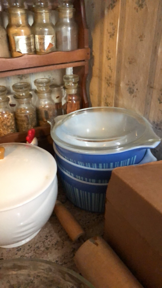 Spice rack, soup bow, l Pyrex bakeware, trivets, rolling pin, and wall decor
