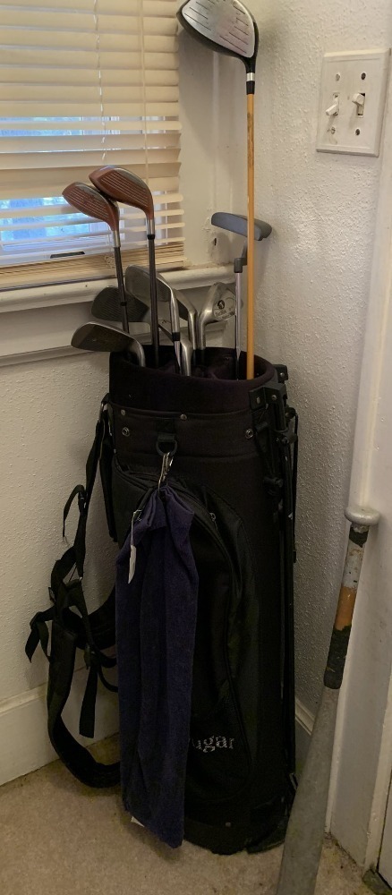 BLACK COUGAR GOLF BAG LOT INCLUDES GOLF BALLS AND LEFT HANDED CLUBS - TOUR EDGE IRONS (5) AND PUTTER (2), 2 TOMMY MANN DRIVERS, 1 AFFINITY DRIVER & 1 OLD METAL BASEBALL BAT -LR