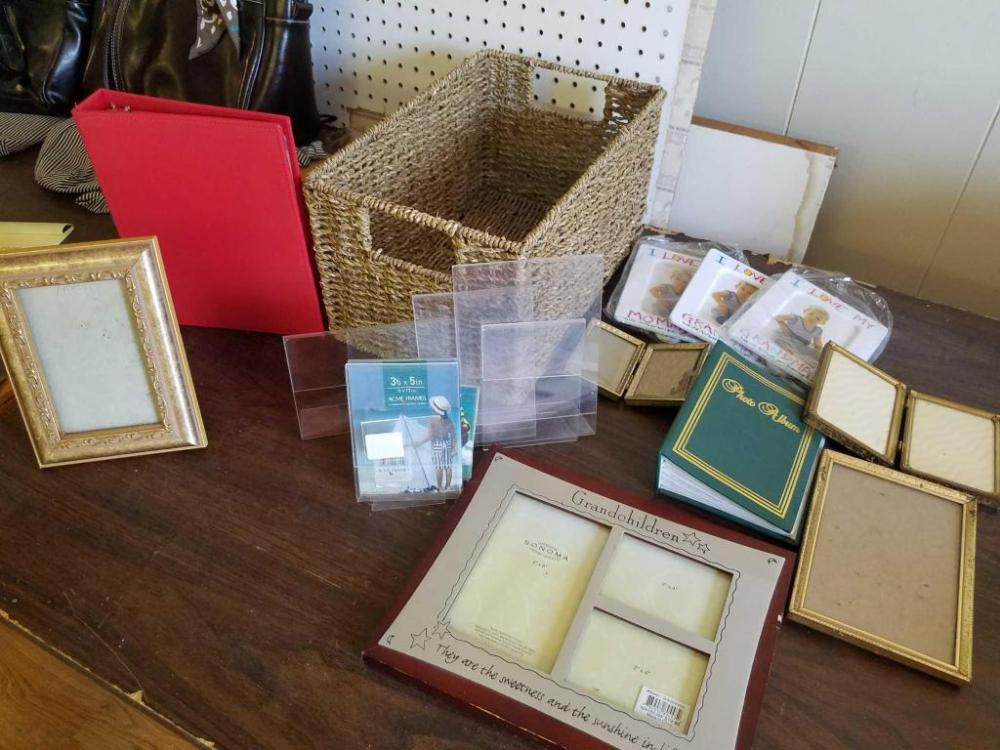 Assortment of small frames, photo book, and basket