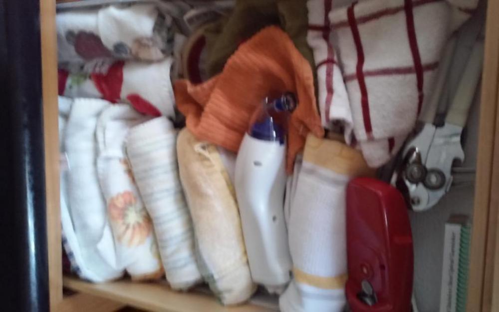 Contents of drawer: dishtowels, can openers, etc